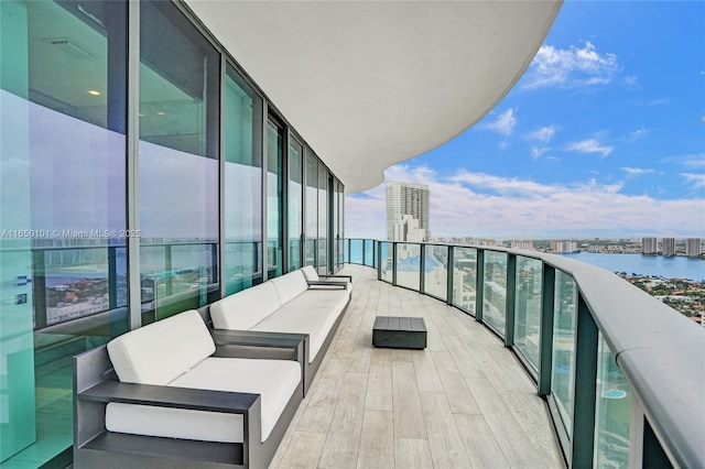 balcony with outdoor lounge area and a water view