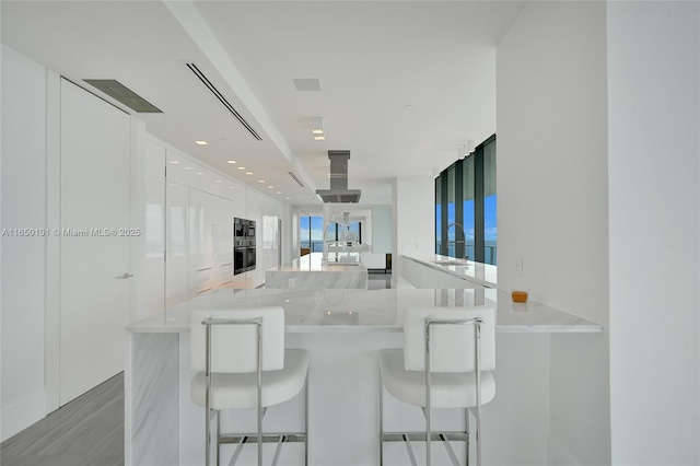 kitchen with a kitchen breakfast bar, white cabinets, and kitchen peninsula