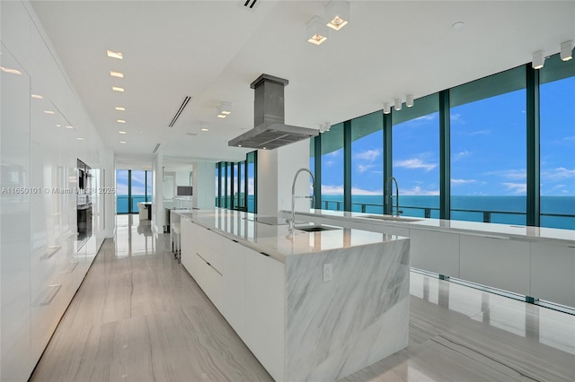 19575 Collins Ave Unit 33, Sunny Isles Beach, FL 33160 - kitchen featuring modern cabinets, white cabinetry, a sink, a large island, and island exhaust hood
