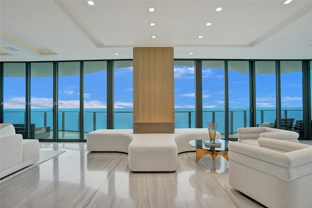 living room featuring a water view, a wealth of natural light, and floor to ceiling windows