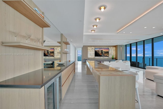 kitchen featuring a wall of windows, light brown cabinets, and a center island