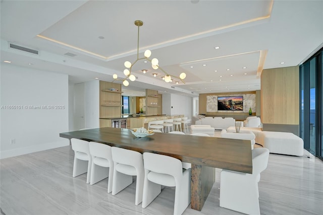 dining area featuring a tray ceiling and a wall of windows