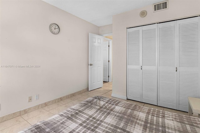 unfurnished bedroom featuring light tile patterned floors and a closet