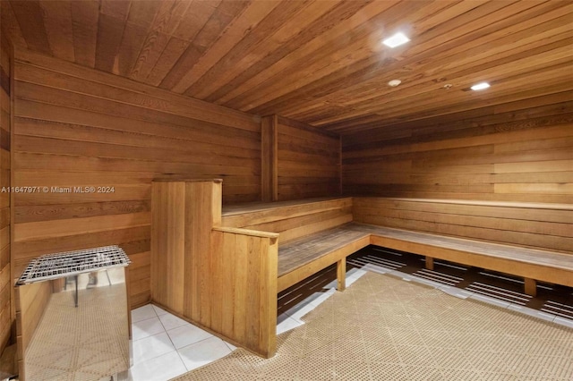 view of sauna / steam room with wooden ceiling, wooden walls, and tile patterned flooring