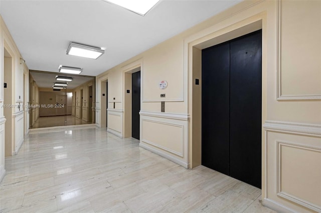 corridor with elevator and light tile patterned flooring