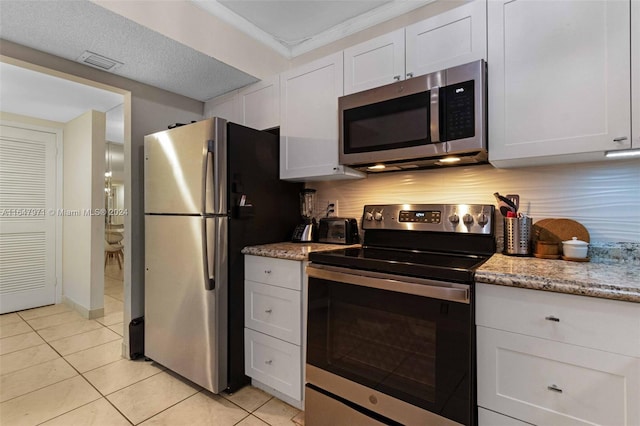 kitchen featuring stainless steel appliances, decorative backsplash, and white cabinets