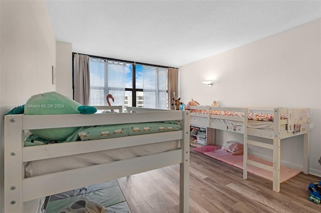 bedroom with a textured ceiling and wood-type flooring