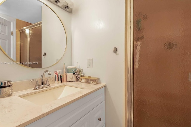 bathroom with vanity and a shower with door