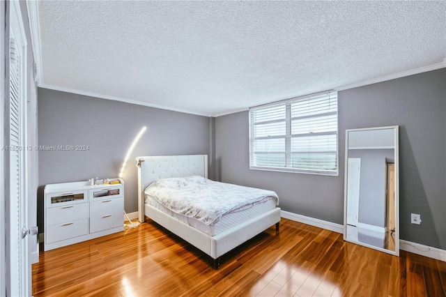 bedroom with a textured ceiling and hardwood / wood-style flooring