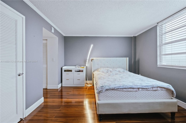 bedroom featuring dark hardwood / wood-style floors, crown molding, and a textured ceiling