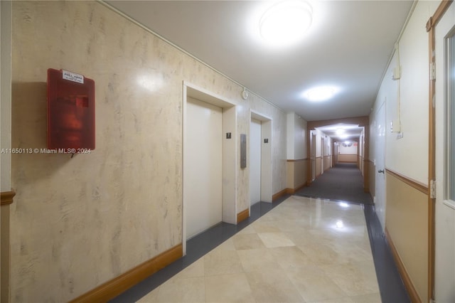 hallway featuring elevator and tile patterned floors