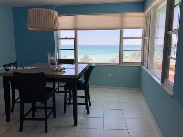 tiled dining room featuring a water view