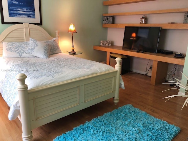 bedroom with wood-type flooring and built in desk