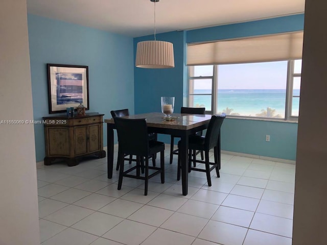 dining room with a water view and light tile patterned floors