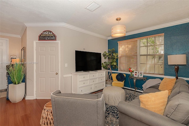 living room with a textured ceiling, crown molding, and hardwood / wood-style floors