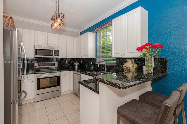 kitchen featuring pendant lighting, kitchen peninsula, decorative backsplash, appliances with stainless steel finishes, and a breakfast bar area