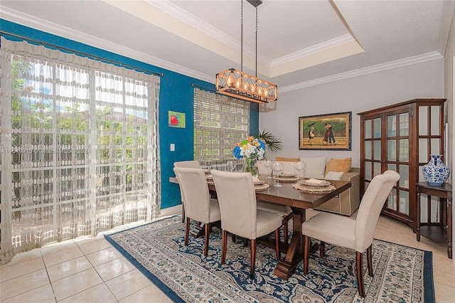 tiled dining space featuring crown molding, an inviting chandelier, and a raised ceiling