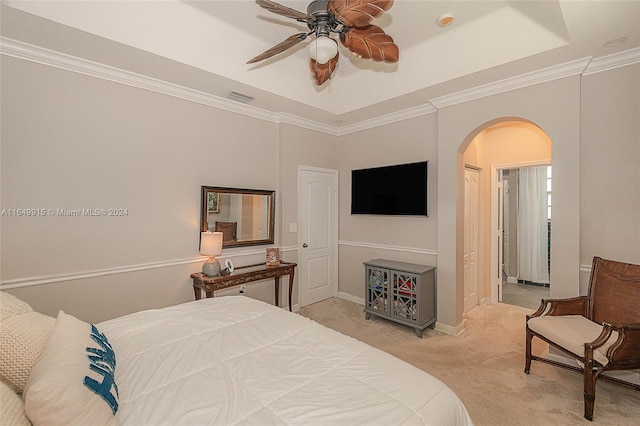 carpeted bedroom with ceiling fan, a raised ceiling, and ornamental molding