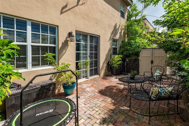 view of patio featuring a storage unit