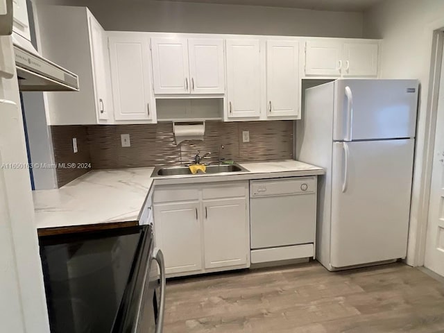 kitchen with white cabinets, light wood-type flooring, white appliances, sink, and decorative backsplash