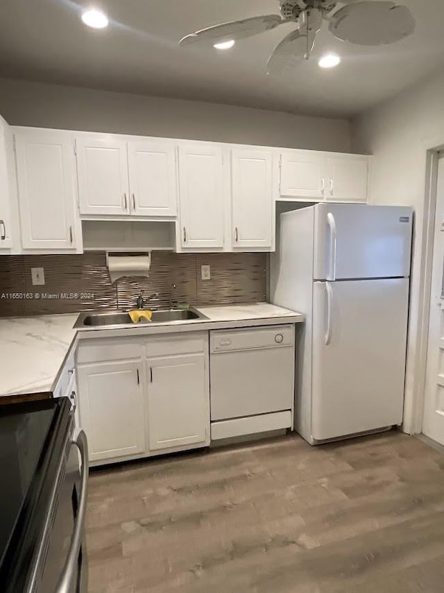 kitchen with white appliances, hardwood / wood-style floors, decorative backsplash, white cabinetry, and ceiling fan