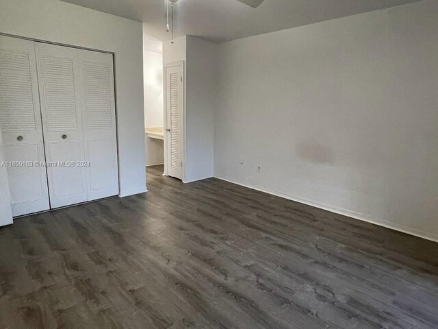 unfurnished bedroom featuring a closet, ceiling fan, and dark hardwood / wood-style floors