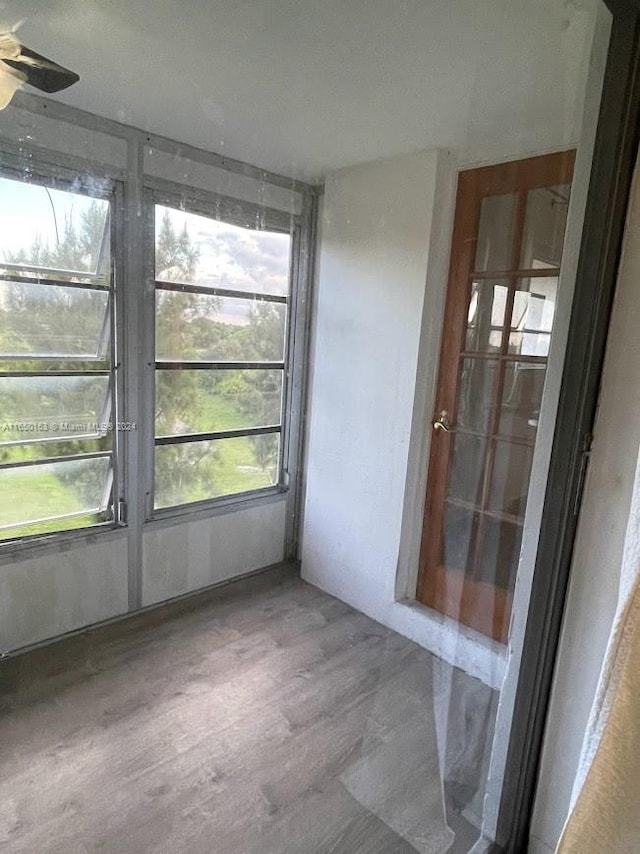 unfurnished sunroom with ceiling fan