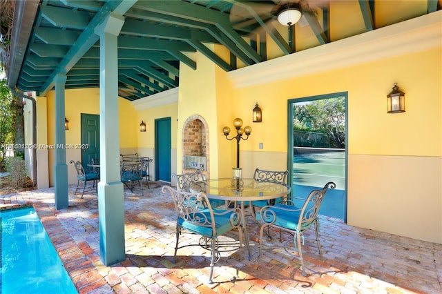 view of patio with outdoor dining area and a ceiling fan