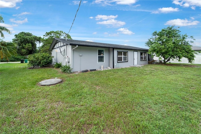 rear view of property featuring a yard