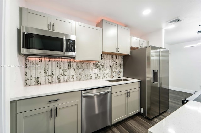 kitchen with sink, appliances with stainless steel finishes, dark hardwood / wood-style flooring, and tasteful backsplash