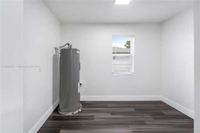 exercise room featuring electric water heater and dark wood-type flooring