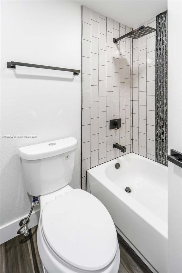 bathroom featuring tiled shower / bath, toilet, and hardwood / wood-style flooring