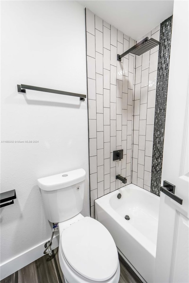 bathroom with toilet, tiled shower / bath combo, and hardwood / wood-style flooring