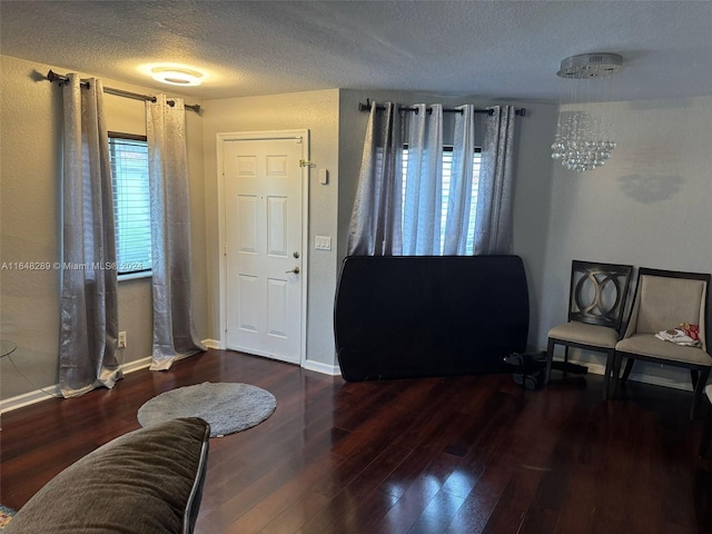 foyer featuring baseboards, a textured ceiling, and wood finished floors