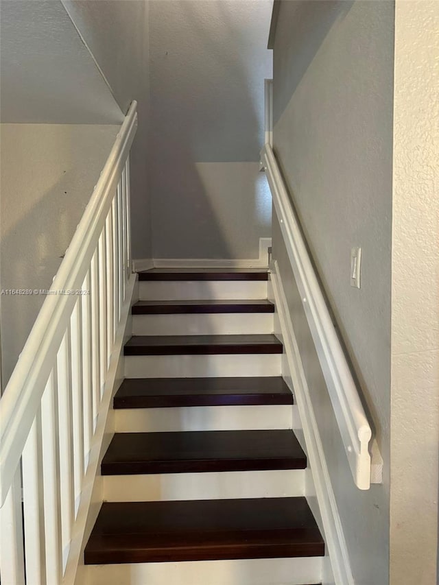 staircase with a textured wall