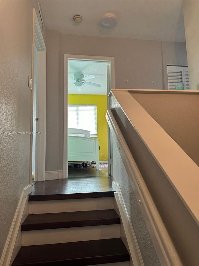 stairway featuring visible vents and a textured wall