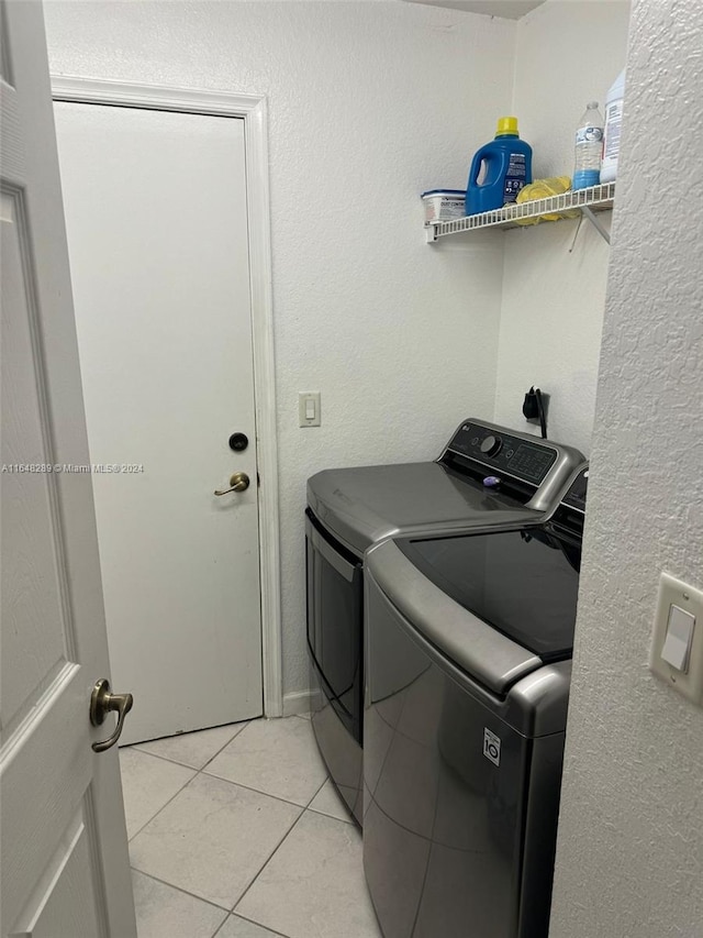 laundry room with laundry area, light tile patterned floors, and washing machine and clothes dryer