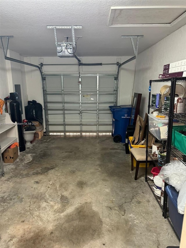 garage featuring a garage door opener and a textured wall