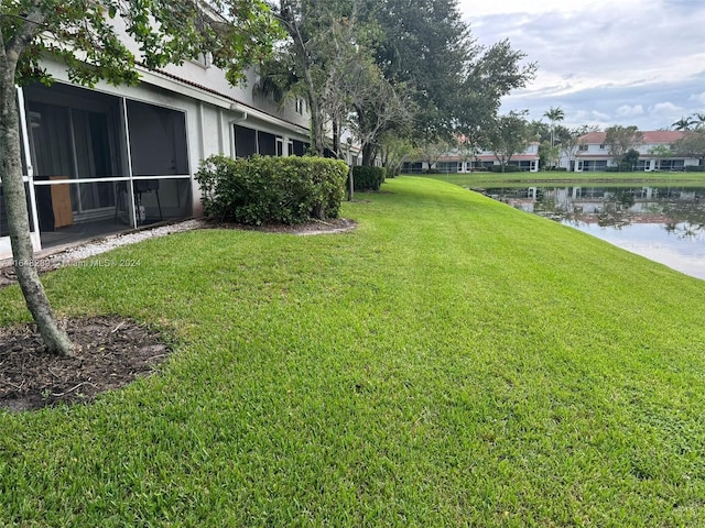 view of yard with a water view and a sunroom