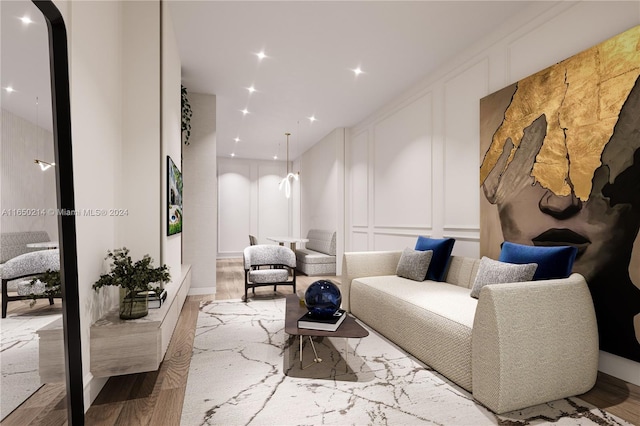 living area featuring arched walkways, a decorative wall, and wood finished floors