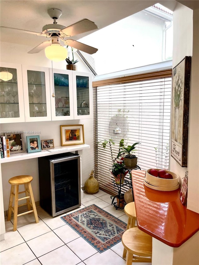 bar with white cabinetry, ceiling fan, beverage cooler, and light tile patterned floors