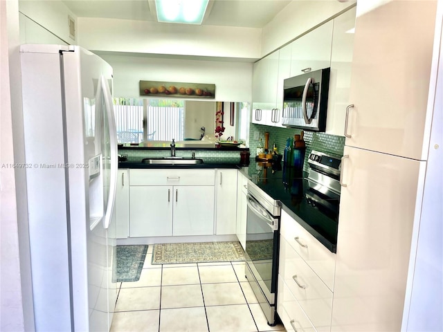 kitchen with white cabinetry, appliances with stainless steel finishes, sink, and backsplash