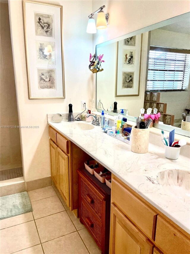 bathroom featuring tile patterned flooring, vanity, and tiled shower