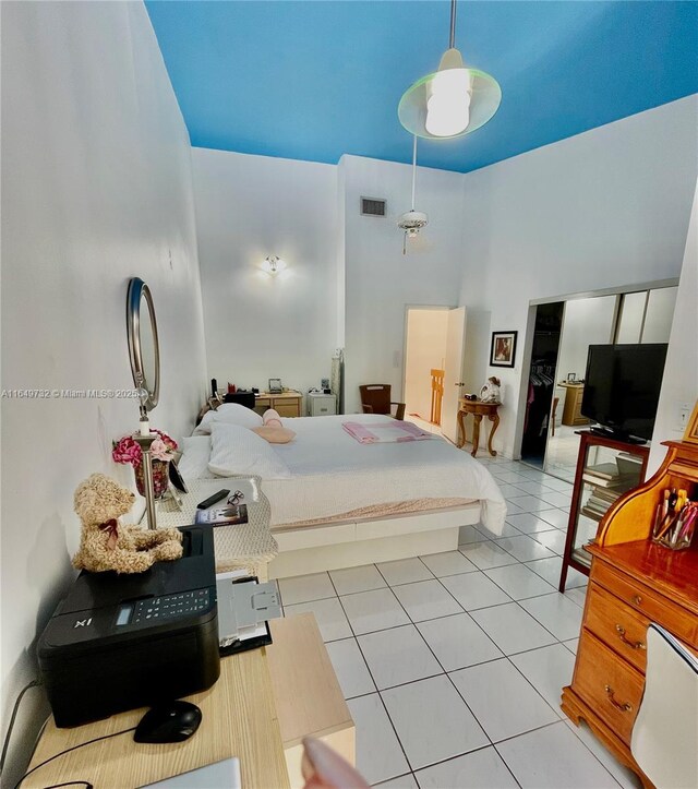 bedroom featuring light tile patterned floors and a high ceiling