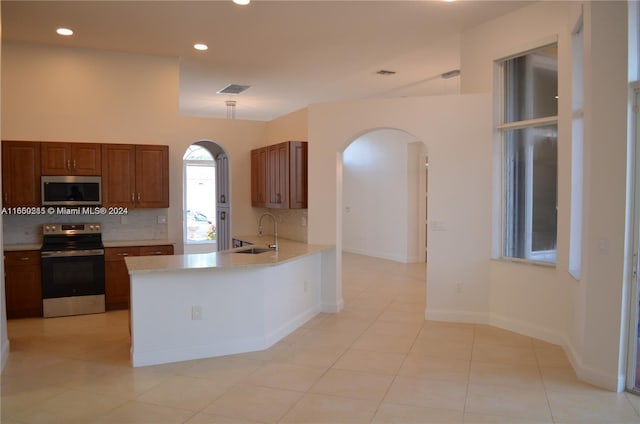 kitchen featuring appliances with stainless steel finishes, tasteful backsplash, and light tile patterned flooring