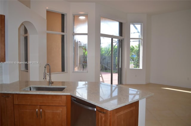 kitchen with plenty of natural light, sink, and light stone countertops