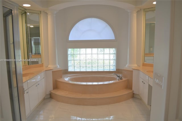 bathroom featuring vanity, a bathing tub, ornate columns, and tile patterned flooring