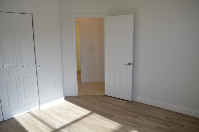 unfurnished bedroom with hardwood / wood-style floors and a closet