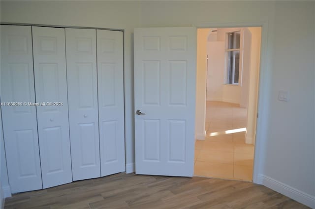 unfurnished bedroom with hardwood / wood-style floors and a closet