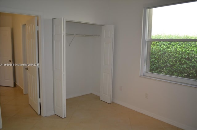 unfurnished bedroom featuring multiple windows and light tile patterned flooring